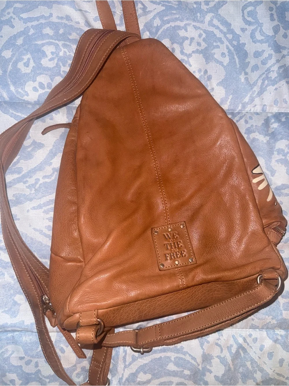 Compact Brown Leather Sling Backpack with Decorative Accents